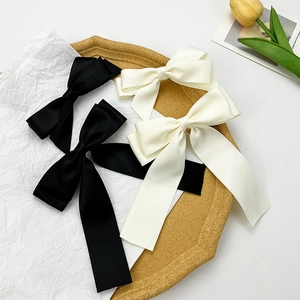 Elegant satin bow hair clip with long ribbons in black and cream for women