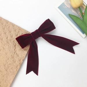 Elegant deep red velvet double-layered bow hair clip with long streamers on white surface