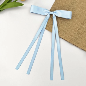Détail d'un nœud de cheveux bleu clair avec de longs rubans en satin soyeux