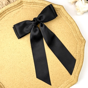 Detail of elegant black grosgrain ribbon hair clip with double layer bow design