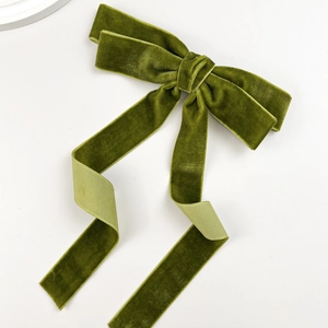 Elegant olive green velvet bow hair clip with long streamers on a white background