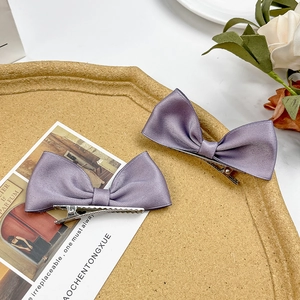 Detail view of lavender satin bow hair clips with elegant silky texture and silver crocodile clip