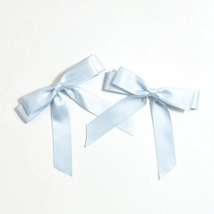Detail of light blue satin ribbon bows with double-layered structure and long silky tails