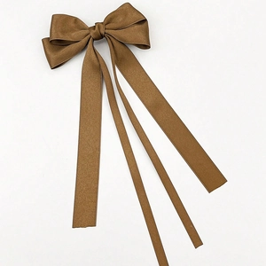 Detailed view of the layered dark brown satin bow clip with long silky ribbons