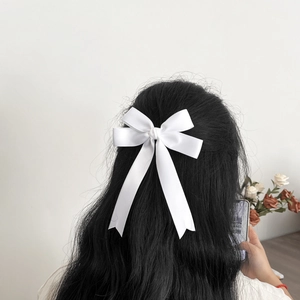 Barrette nœud en satin blanc élégant sur cheveux noirs longs pour un style minimaliste