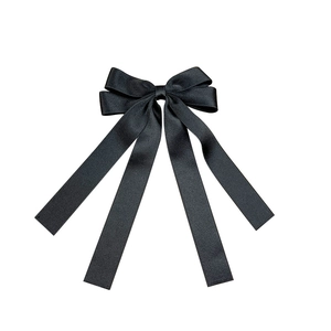 Elegant black satin bow hair clip with long ribbons for a minimalist hair accessory look