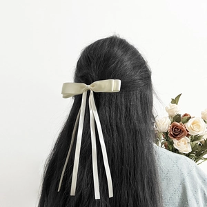 Elegant cream satin double bow hair clip with long ribbons for a sweet ponytail hairstyle