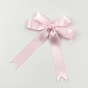 Vue détaillée du nœud en satin rose avec de longs rubans fluides pour les cheveux