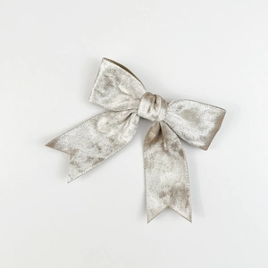 Detailopname van de champagne fluwelen strik met luxe zachte textuur en knoopdetails