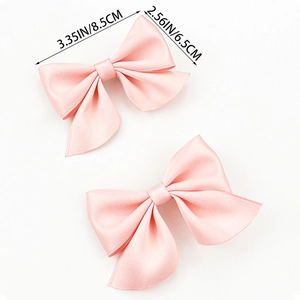 Détail des barrettes nœuds en satin rose avec dimensions de 8,5 cm par 6,5 cm