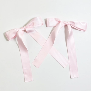 Detail of pink satin ribbon hair bows with long flowing streamers for girls