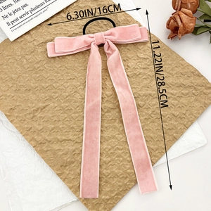 Pink velvet bow hair scrunchie with long ribbons for elegant ponytail styling