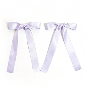 Detail of lavender satin ribbon hair bows with long elegant streamers and silky texture