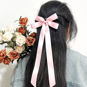 Barrette à cheveux élégante en satin rose avec long ruban sur cheveux noirs