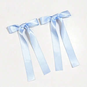 Detail of light blue satin ribbon bow hair clips with long streamers for elegant hair styling