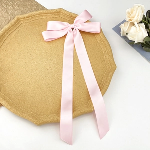 Gros plan détaillé d'un nœud en ruban de soie rose clair avec texture satinée lisse