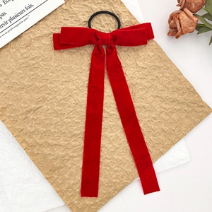 Japanese style red velvet bow hair scrunchie with long ribbons on vintage paper background