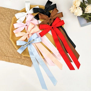 Détail de barrettes à nœuds en satin avec longs rubans et clips en métal en sept couleurs