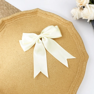 Détail du nœud papillon en satin crème avec de longs rubans élégants pour cheveux