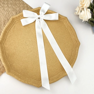 Détail d'un nœud papillon en satin blanc élégant avec de longs rubans sur un socle