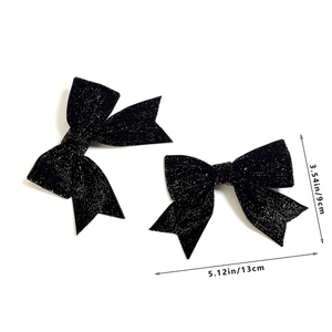 Detail view of double black glitter bow hair clips showing 13cm width and 9cm height dimensions