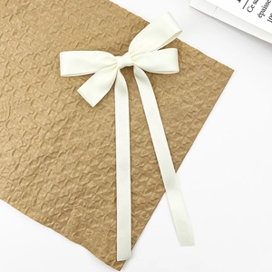 Elegant cream white satin bow hair clip with long ribbons for a sweet minimalist style
