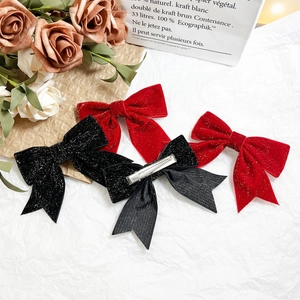 Elegant velvet bow hair clips in red and black with sparkly finish and metal duckbill clips