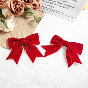 Sparkling red velvet bow hair clips with gold sequins on elegant white background
