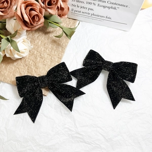 Sparkly black velvet bow hair clips with shimmering sequins in a romantic gift setting