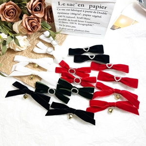 Close-up of velvet bow hair clips with heart rhinestones and golden bells set