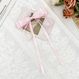 Barrette à cheveux élégante en satin rose clair avec de longs rubans et un fini nacré doux