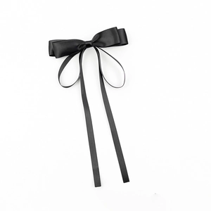 Détail d'un élégant nœud en satin noir avec de longs rubans et une texture soyeuse