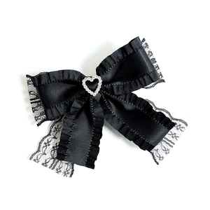 Elegant black lace bow hair clip with a sparkling rhinestone heart on a white background