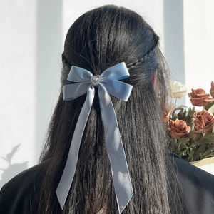 Barrette nœud en satin bleu clair avec strass en cœur sur cheveux de mannequin