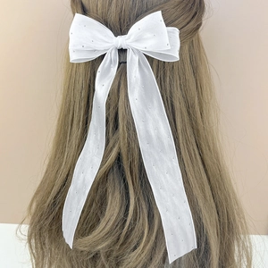 Elegant white mesh bow hair clip with rhinestones and long streamers on long hair
