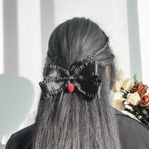 Barrette élégante en satin noir avec nœud et détail fraise rouge sur cheveux longs