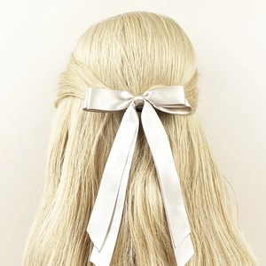 Elegante fermaglio per capelli con fiocco in raso oro champagne su lunghi capelli biondi
