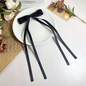 Detailansicht einer eleganten schwarzen Haarspange mit Spitzenschleife und langen Bändern