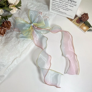Detail einer Makronen-Gradient-Organza Haarschleife mit Golddrahtkanten und Bändern