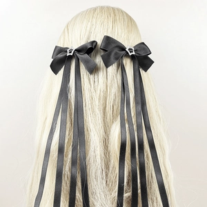 Nœuds en ruban de soie noire avec strass en forme d'étoile sur longs cheveux blonds