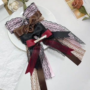 Gothic lace bow hair clips with long ribbons in punk Lolita style on a white plate