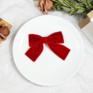Red velvet bow hair clip for women, vintage style hair accessory on a decorative plate