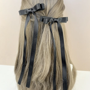 Elegant pair of black silk ribbon bow hair clips with long streamers for women's hairstyling