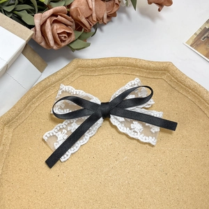 Elegante haarclip van wit bloemenkant met zwart satijnen lint in vintage esthetische stijl