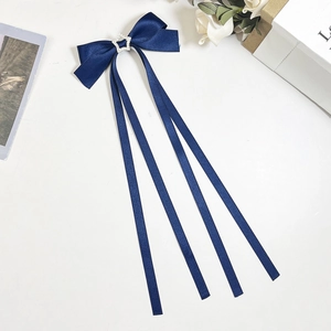 Gros plan sur le nœud en satin bleu marine avec étoile en strass et longs rubans