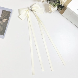 Détail du nœud en satin crème avec étoile en strass et longs rubans pour cheveux