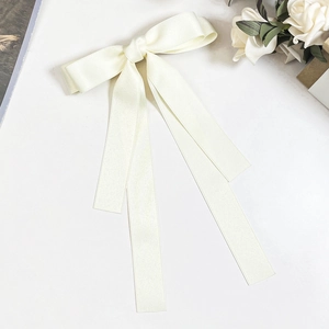 Detailaufnahme der cremefarbenen Satin-Haarklammer mit langen Bändern auf Marmor