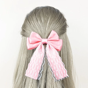 Elegant pink satin bow hair clip with white lace ribbons for a sweet vintage hairstyle