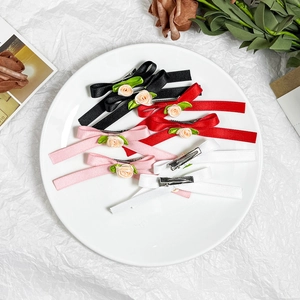 Pastel floral ribbon hair clips in four colors on a white plate with garden style aesthetic