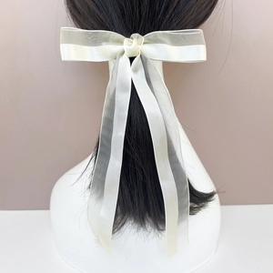 Elegant beige bow hair clip with sheer organza ribbon on model back view